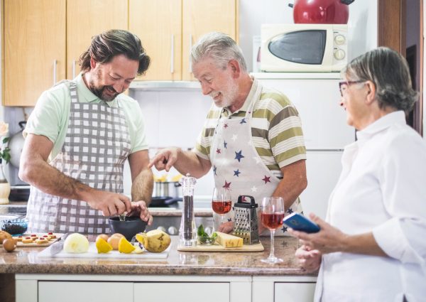 Caucasian,Family,Three,Man,People,Cook,Together,Lokking,The,How caucasian family three man people cook together lokking the how to do on the mobile phone of the mother. everybody have fun and laugh preparing something to eat. white and bright image